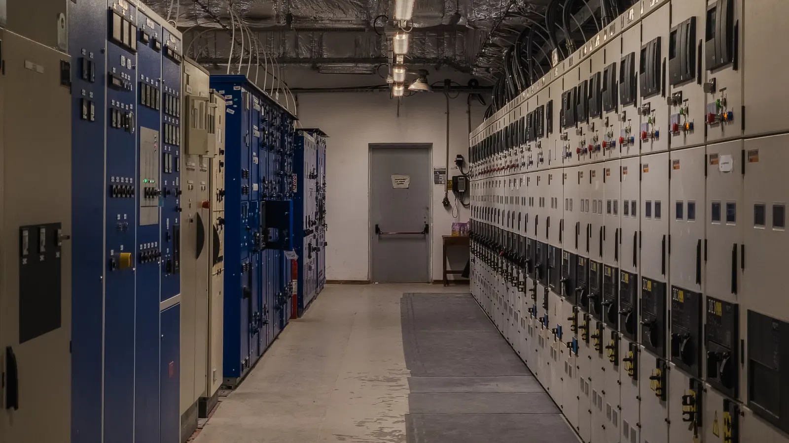 A control room with rows of electrical panels